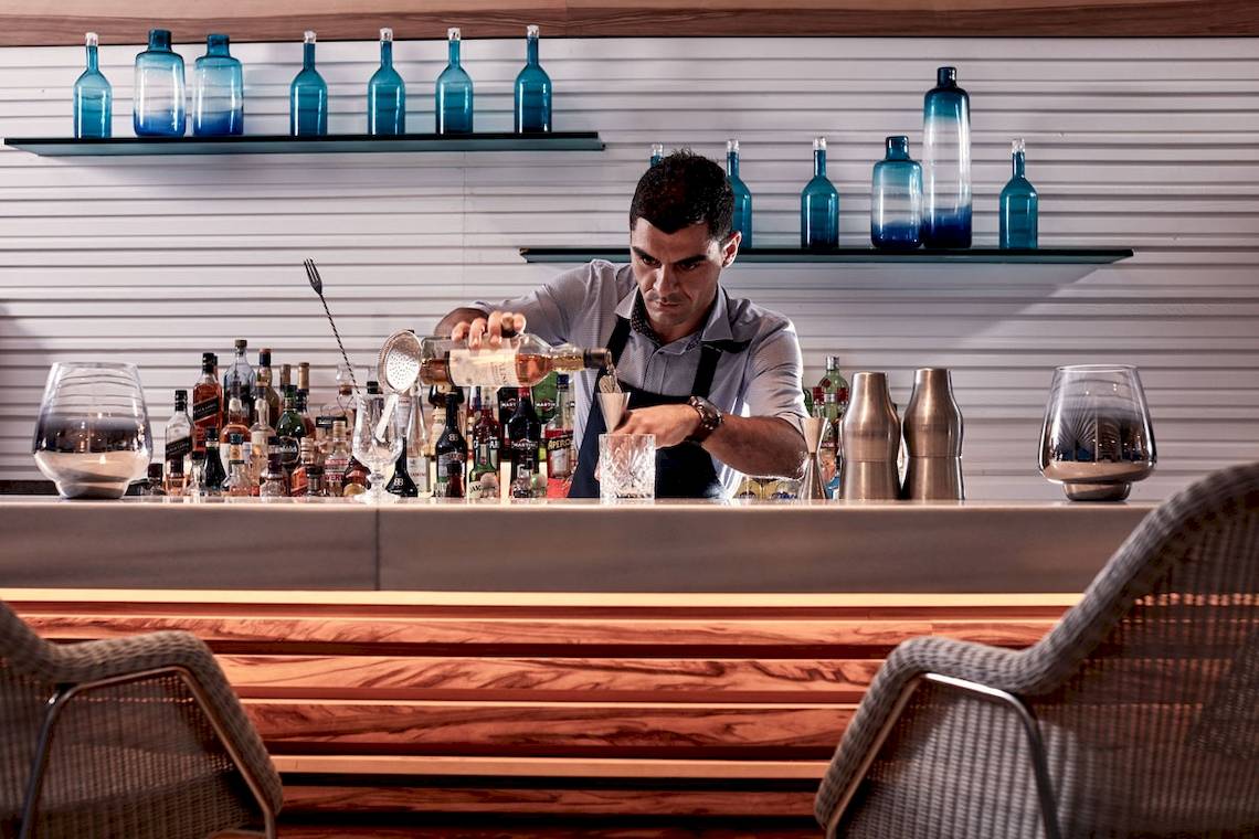 Barkeeper im Myconian Ambassador Hotel schenkt einen Drink ein.