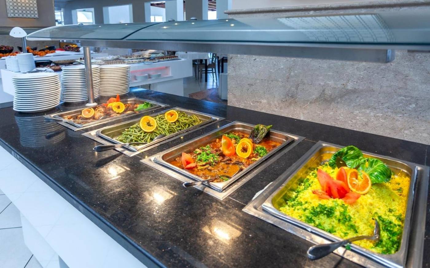 Buffet-Tisch im Djerba Holiday Beach Hotel mit verschiedenen Gerichten und Früchten.