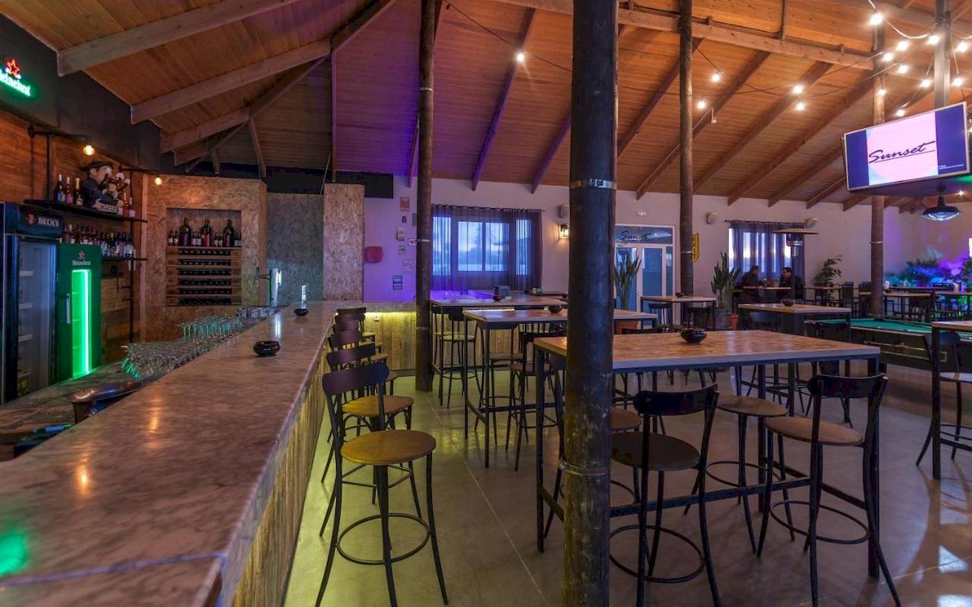 Innenbereich des Djerba Holiday Beach Hotels mit Bar, Tischen und Stühlen.