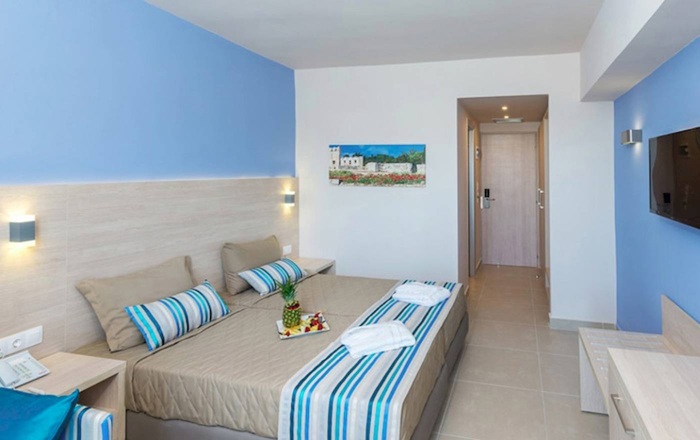 Doppelbettzimmer im Irene Palace Beach Resort Hotel mit blauen Wänden und Bettwäsche.