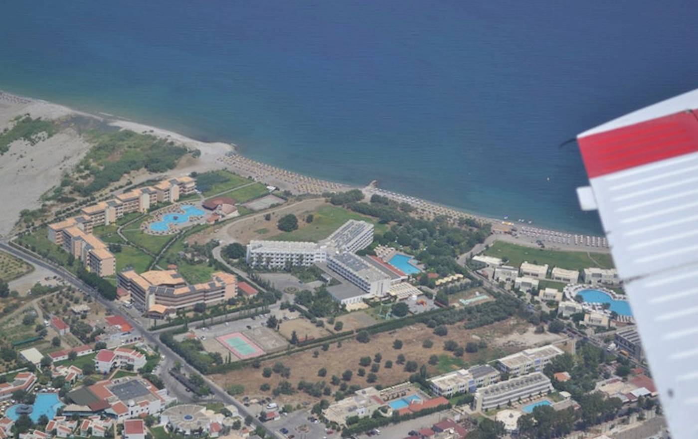 Luftaufnahme des Irene Palace Beach Resorts mit Blick auf die Küste und mehrere Gebäude, darunter Pools.