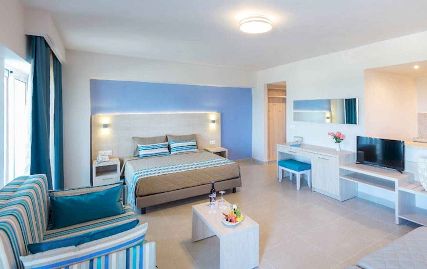 Modernes Zimmer im Irene Palace Beach Resort mit Bett, Tisch, Fernseher und Badezimmer