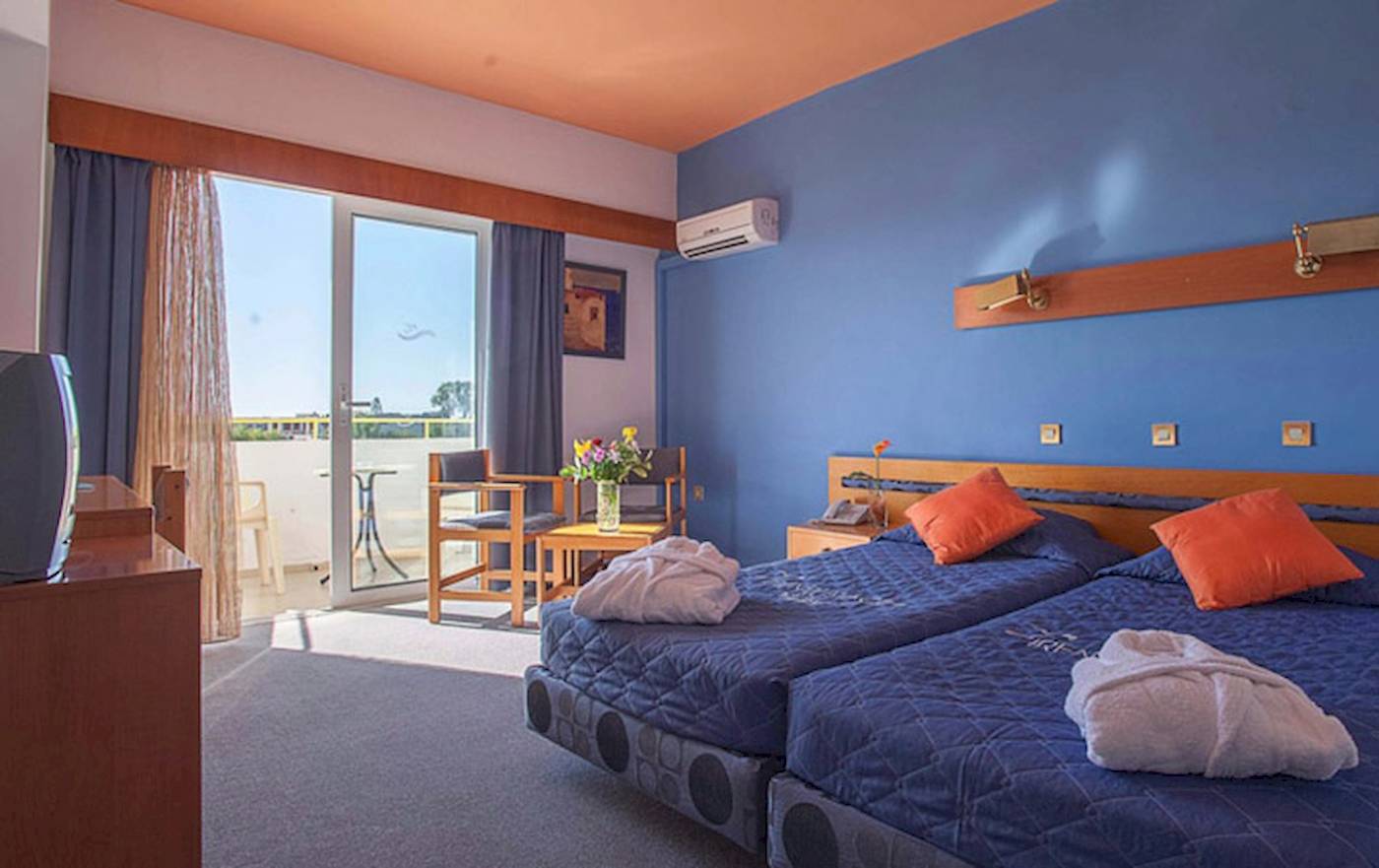 Doppelzimmer im Irene Palace Beach Resort mit zwei Betten, Balkon und Klimaanlage.