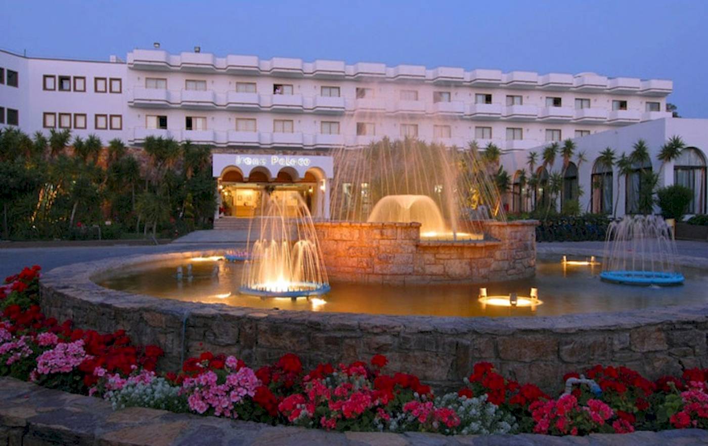 Eingang des Irene Palace Beach Resorts mit Springbrunnen und Blumenbeet.