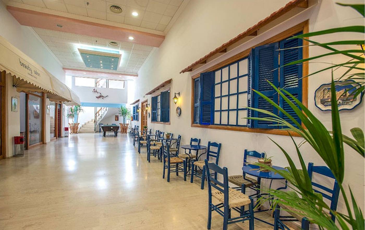 Innenbereich des Irene Palace Beach Resorts mit blauen Stühlen und Tischen.