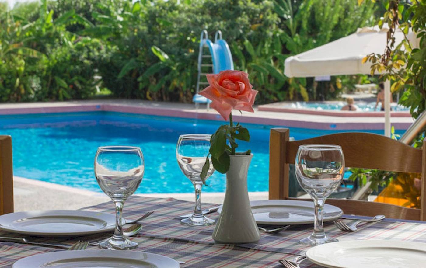 Ein Tisch im Irene Palace Beach Resort mit einem Pool im Hintergrund.