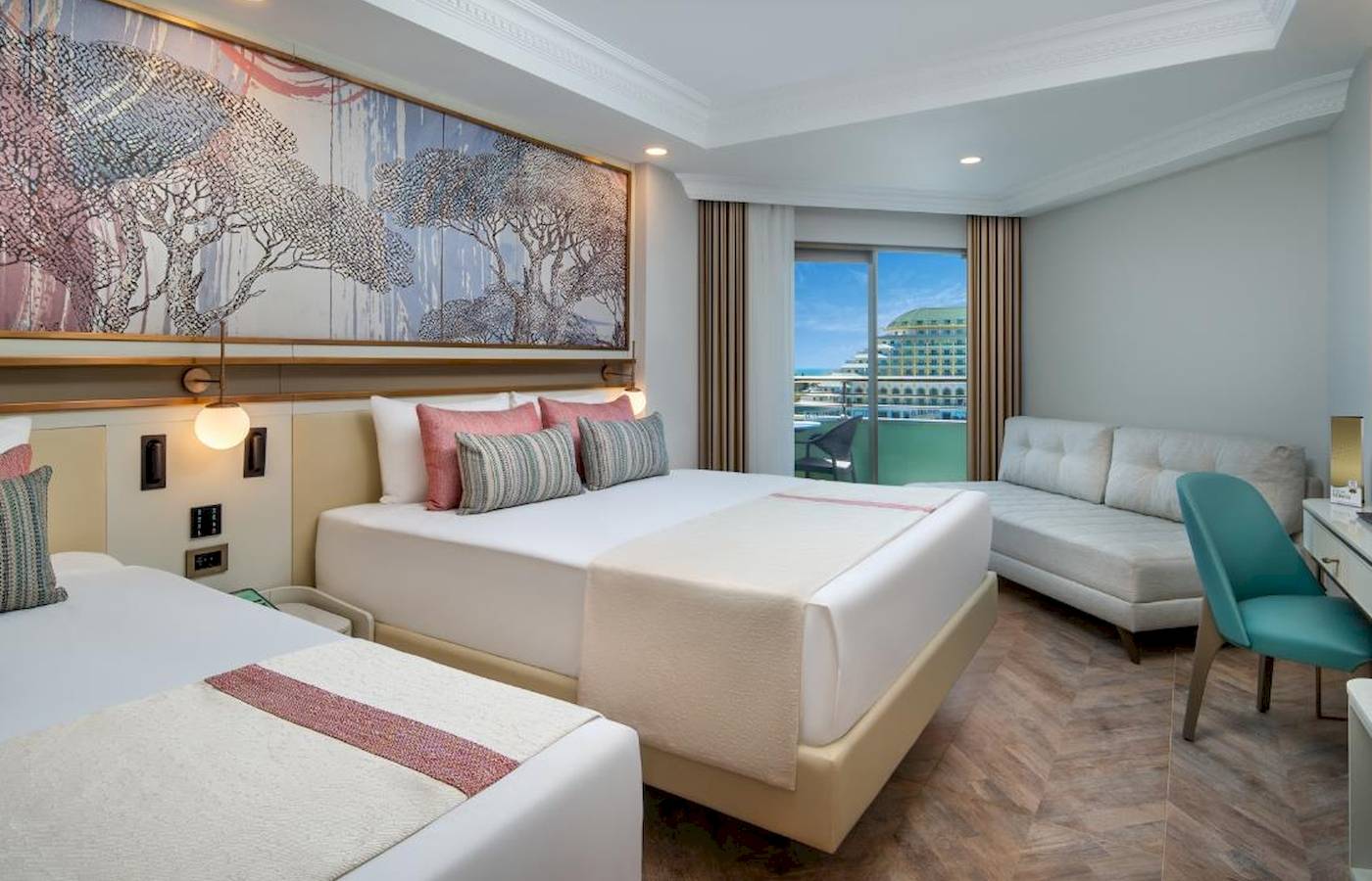 Doppelzimmer im Delphin Palast Hotel mit zwei Betten, Sofa und großer Fensterfront.