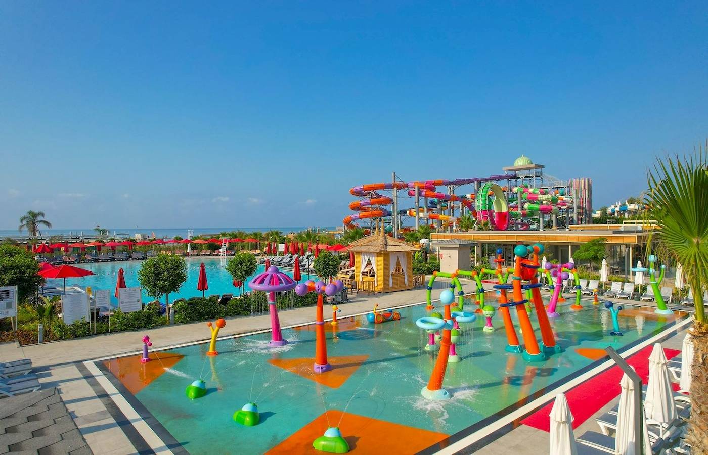 Außenansicht des Delphin Palace Wasserparks mit bunten Wasserrutschen und einem großen Pool.