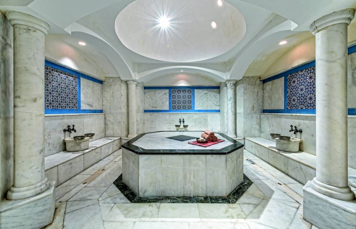 Spa-Bereich im VONRESORT Golden Coast mit achteckigem Becken, Marmorwänden und Säulen.