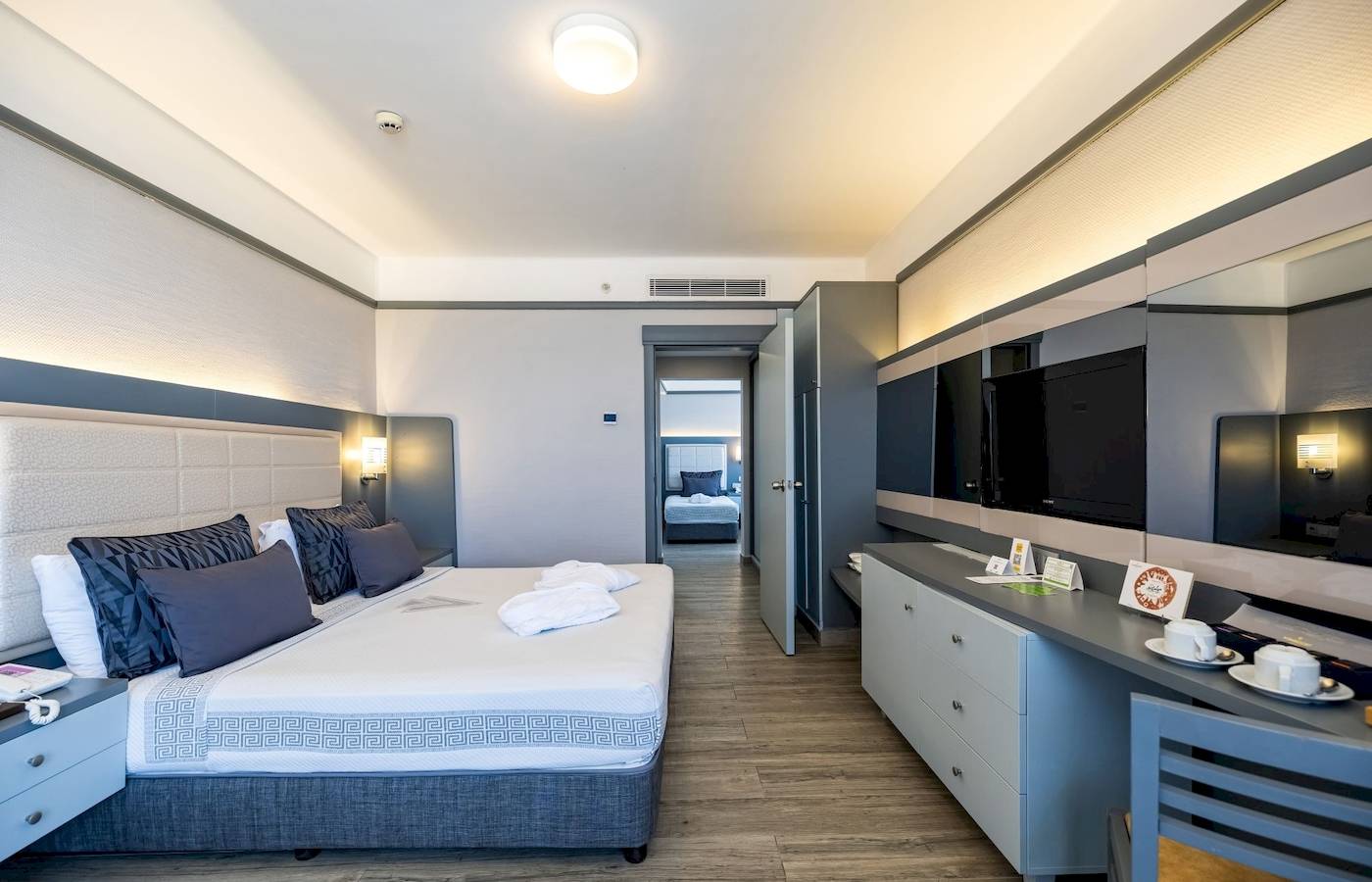 Vonresort Golden Coast Hotelzimmer mit großem Bett, Schränken und Fernseher.