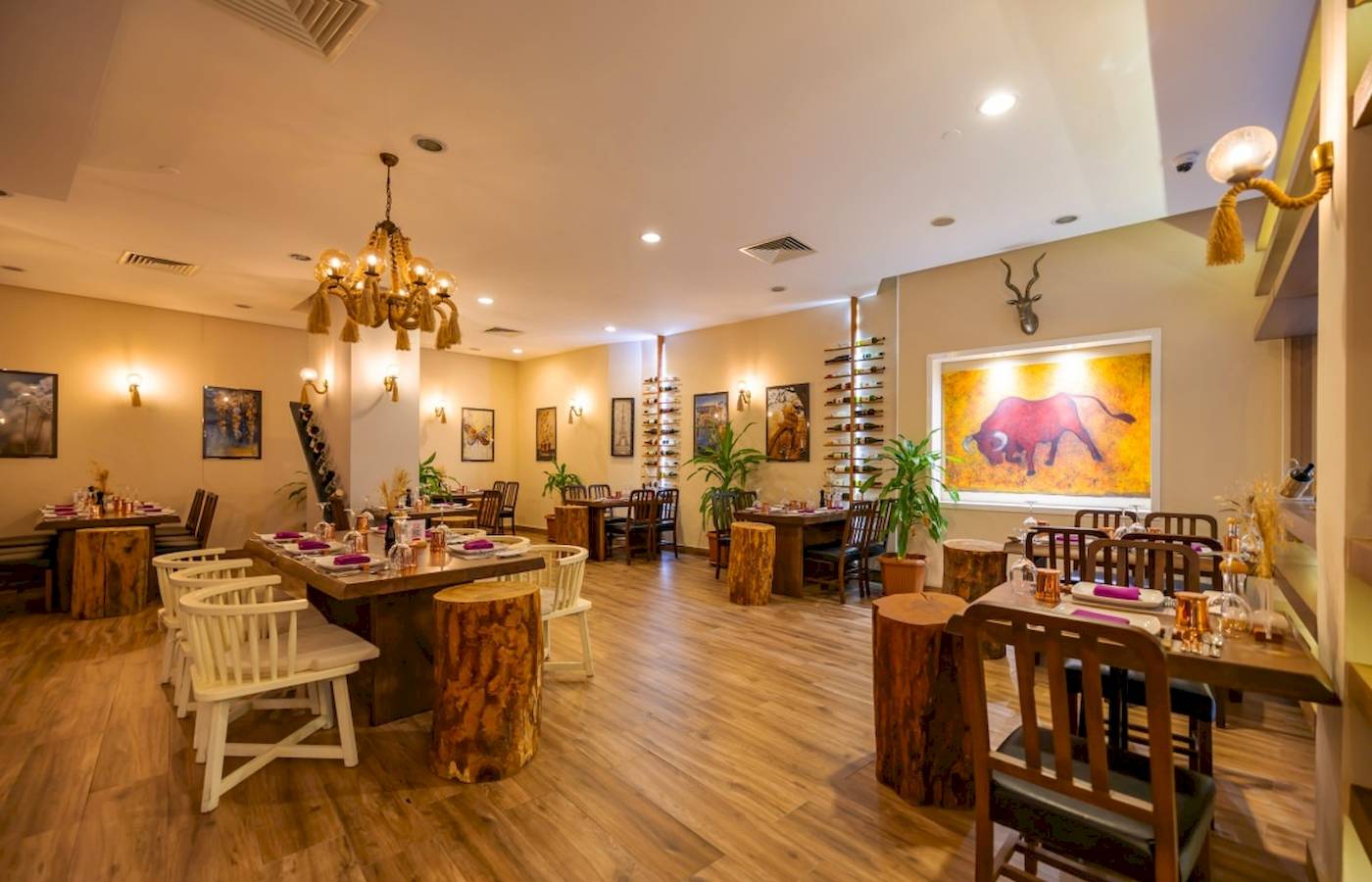 Innenbereich des Restaurants im VONRESORT Golden Coast mit Holztischen, Stühlen und dekorativen Elementen.