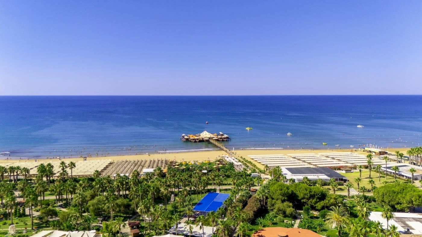 Luftaufnahme des VONRESORT Golden Coast am Strand mit Meer, Palmen und Gebäuden.