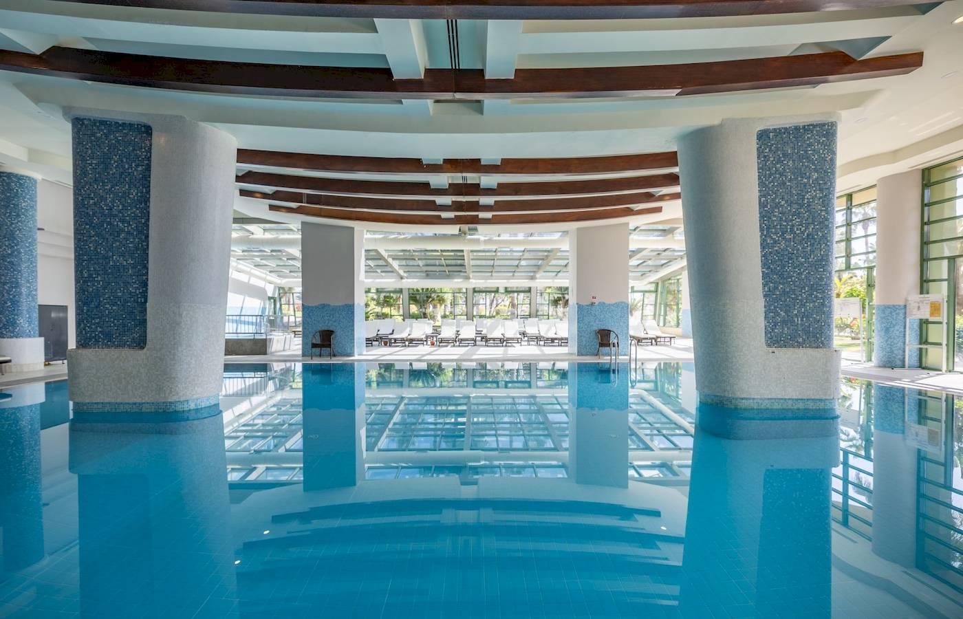 Innenpool des VONRESORT Golden Coast mit blauen Säulen und gefliestem Boden.