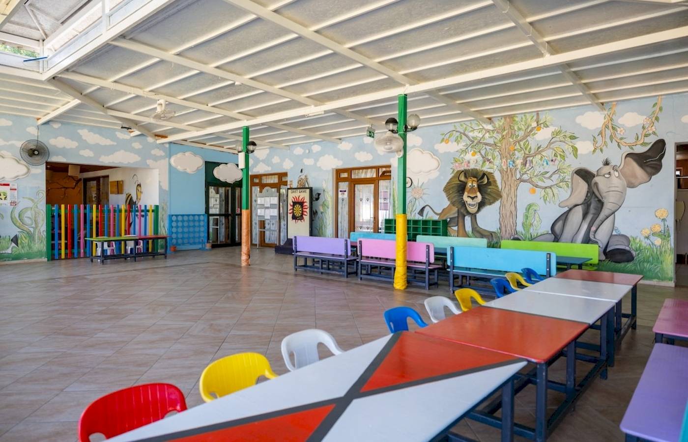 Kinderspielplatz im VONRESORT Golden Coast mit bunten Bänken und Tiermalereien an der Wand.