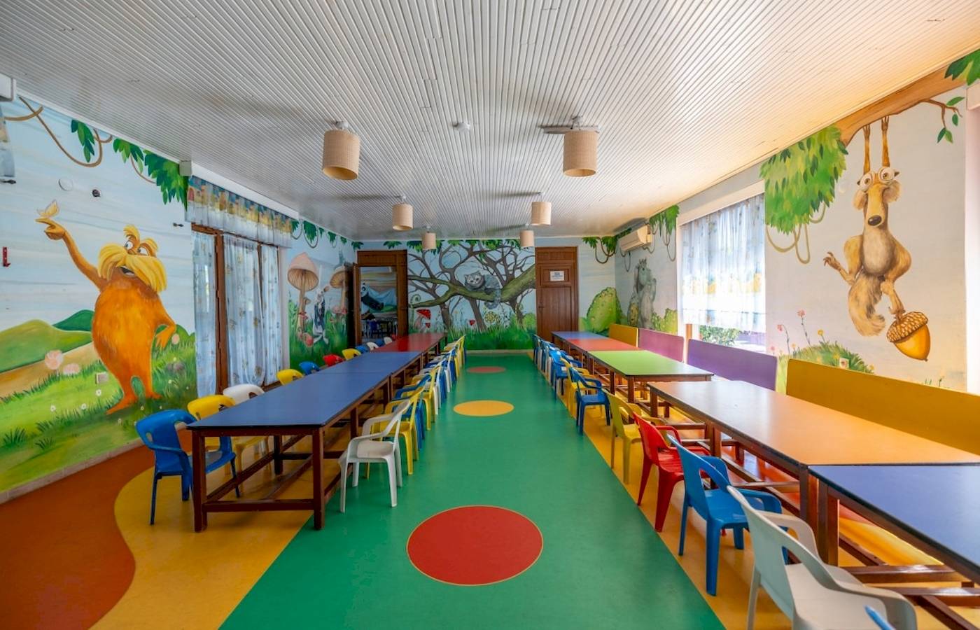 Kinderzimmer im VONRESORT Golden Coast mit grünem Boden und bunten Wandmalereien.