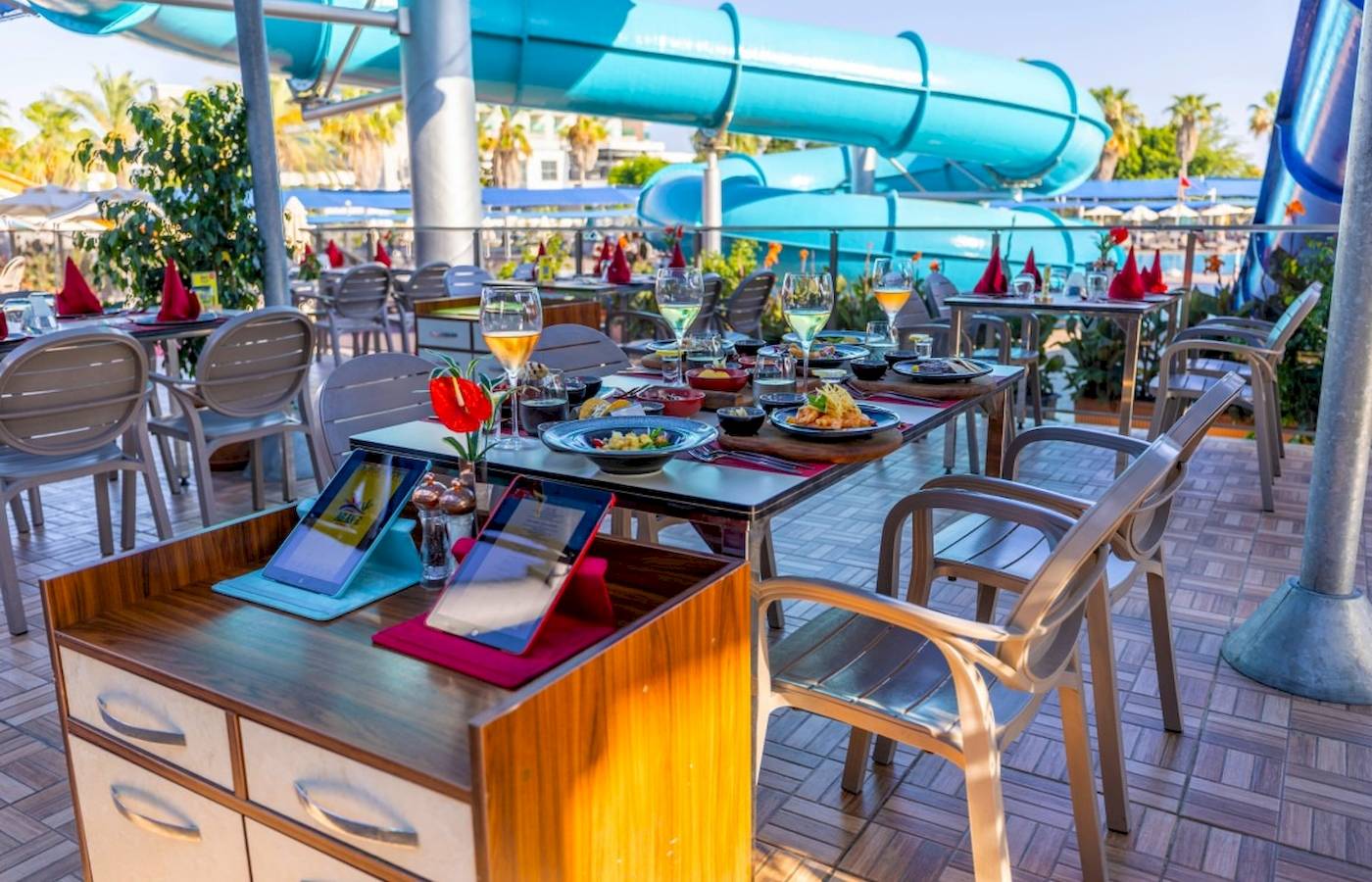 Terrasse im VONRESORT Golden Coast mit einer Wasserrutsche im Hintergrund.