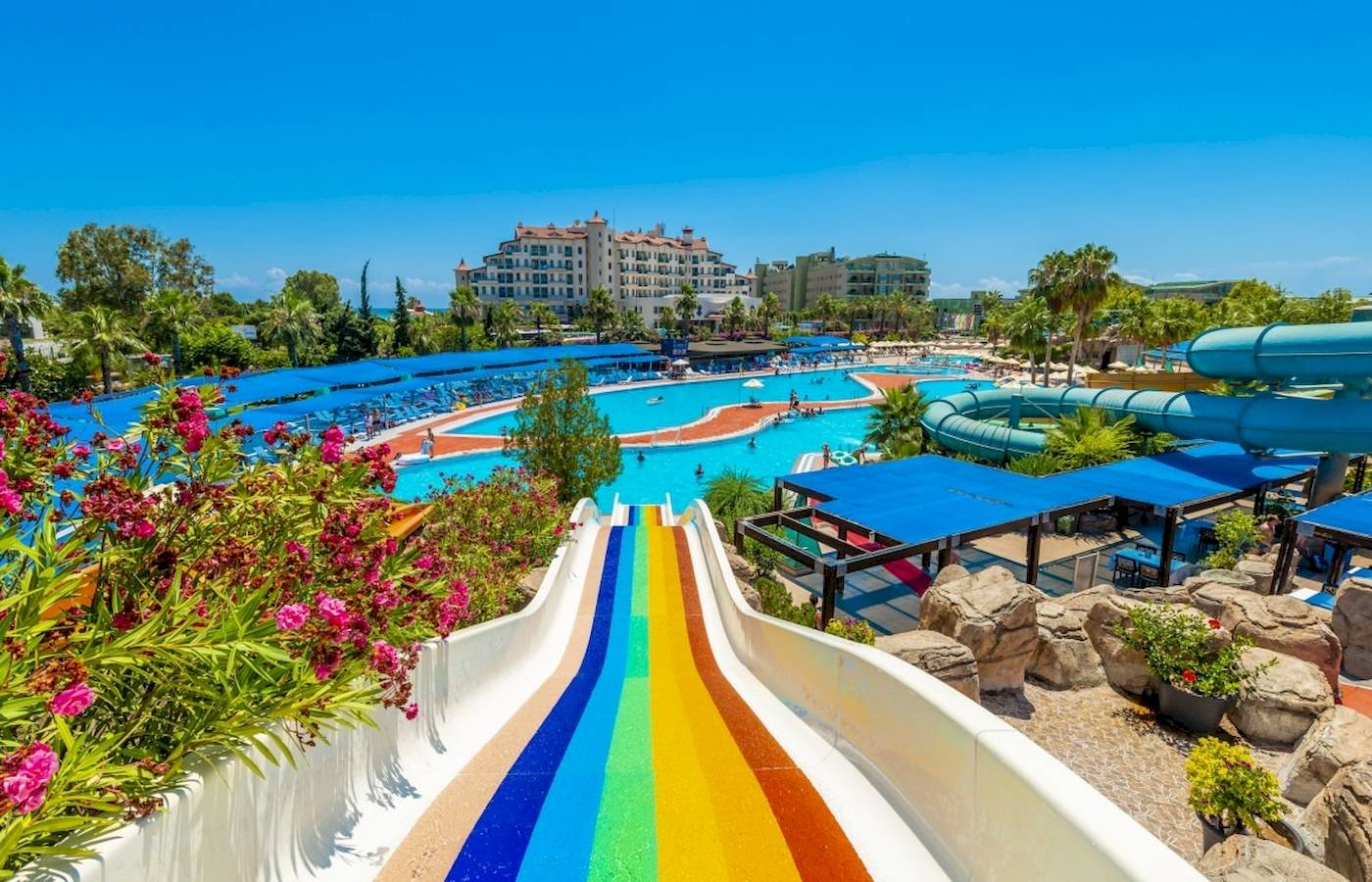 Wasserpark im VONRESORT Golden Coast mit bunter Rutsche und blauen Sonnenschirmen