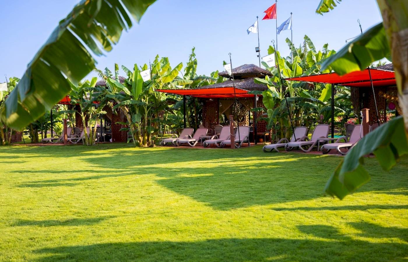 Loungebereich des VONRESORT Golden Coast mit Sonnenliegen und Pavillons.