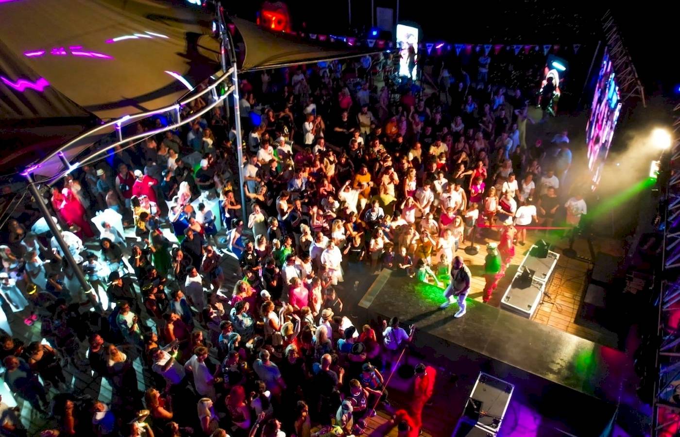 Foto eines vonresort golden coast nachtclub events mit vielen tanzenden leuten und bunten lichtern