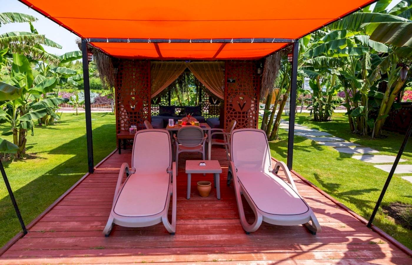 Lounge-Bereich des VONRESORT Golden Coast mit zwei pinken Liegen und einer Tisch.