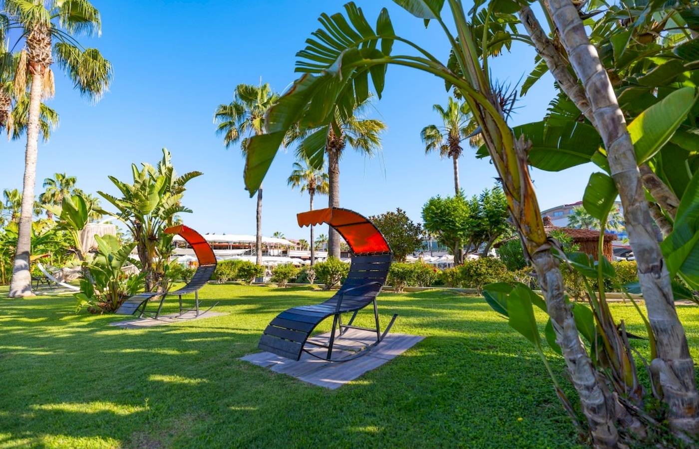 Zwei orange und schwarze Liegestühle auf dem Rasen im Garten des VONRESORT Golden Coast