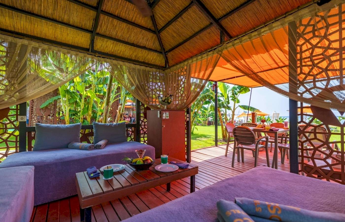 Terrasse im Vonresort Golden Coast mit Sofas, Tisch und Früchten