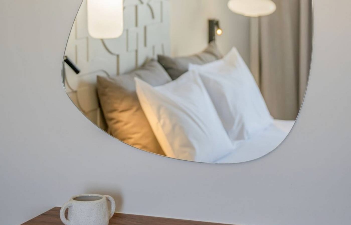 Ein Hotelzimmer im Georgioupolis Resort Aquapark & SPA mit einem Bett, das in einem Spiegel reflektiert wird.