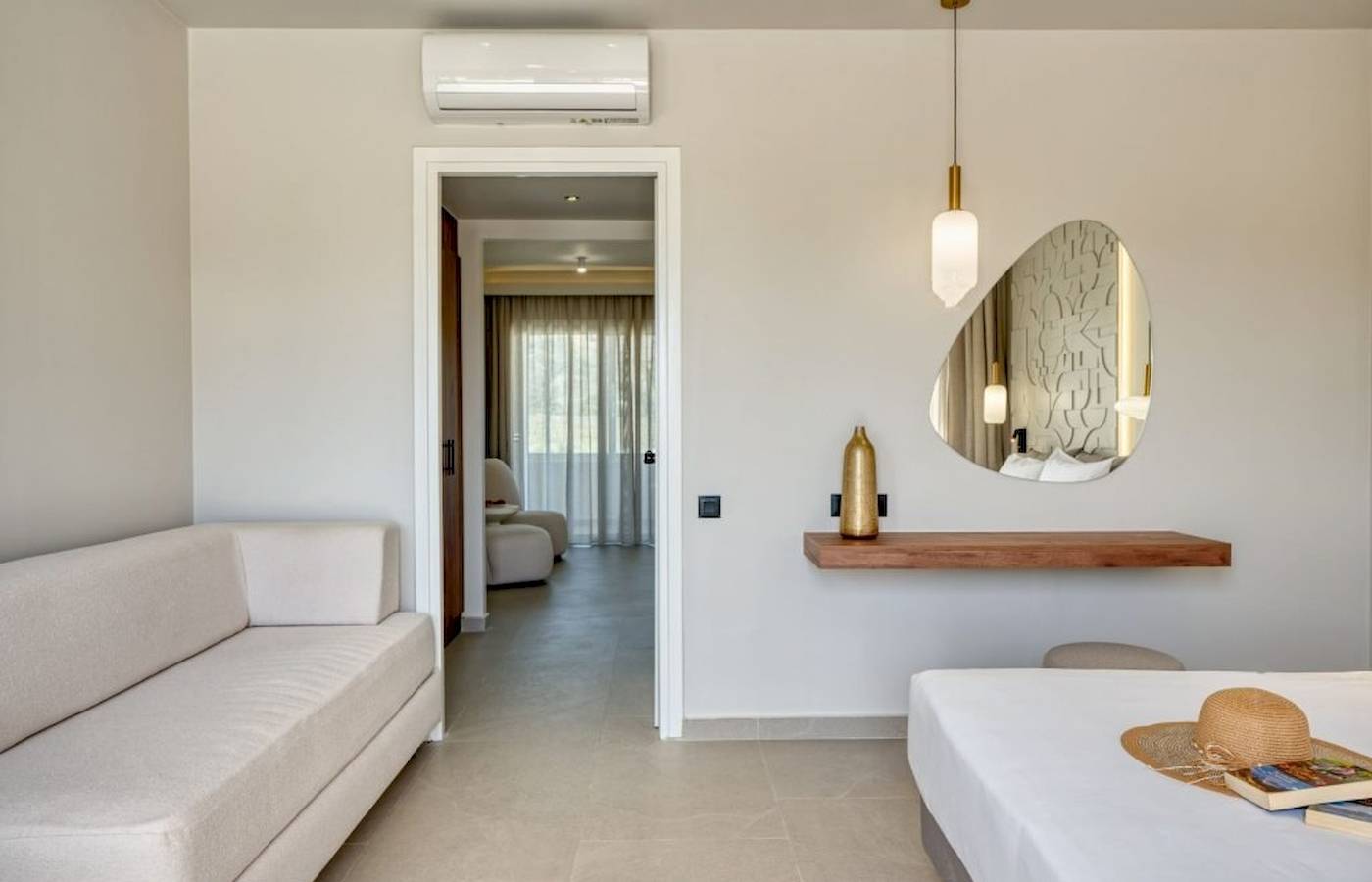 Innenansicht eines Zimmers im Georgioupolis Resort Aquapark & SPA mit Sofa, Bett, Spiegel und Dekoration.