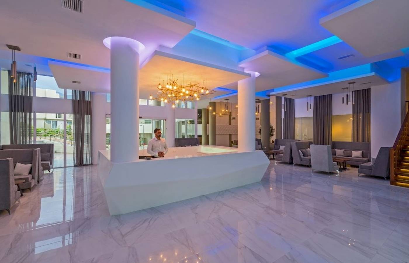 Lobby des Georgioupolis Resort Aquapark & SPA mit Rezeption und modernen Möbeln.