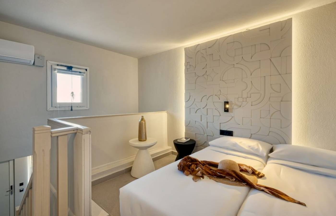 Innenansicht eines Schlafzimmers im Georgioupolis Resort Aquapark & SPA mit weißen Wänden, einem Bett, Nachttischen und einer Klimaanlage.