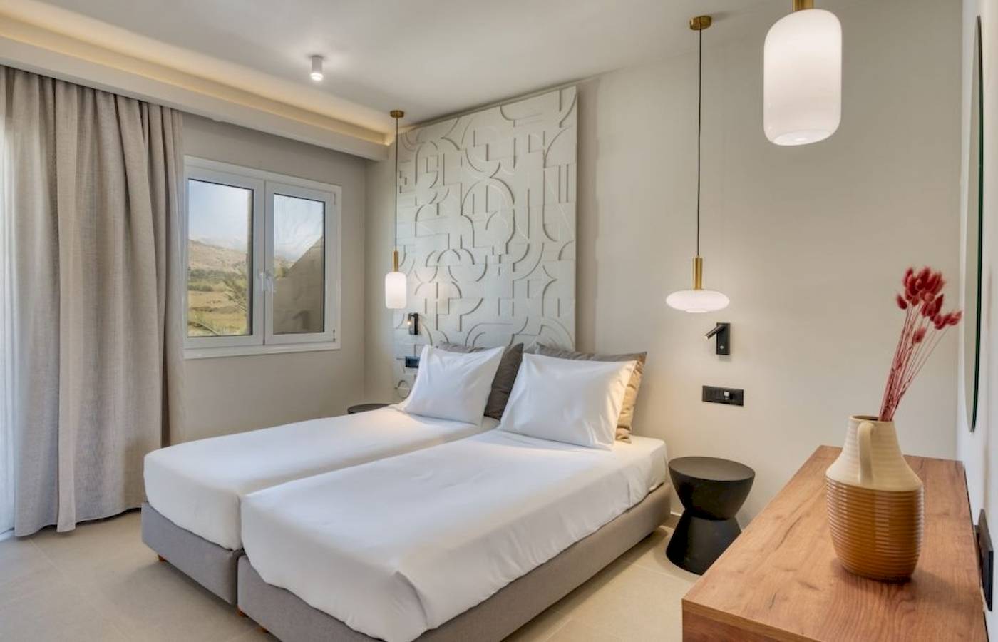 Innenansicht eines Doppelzimmers im Georgioupolis Resort Aquapark & SPA mit zwei Betten, weißem Bettzeug und moderner Einrichtung.