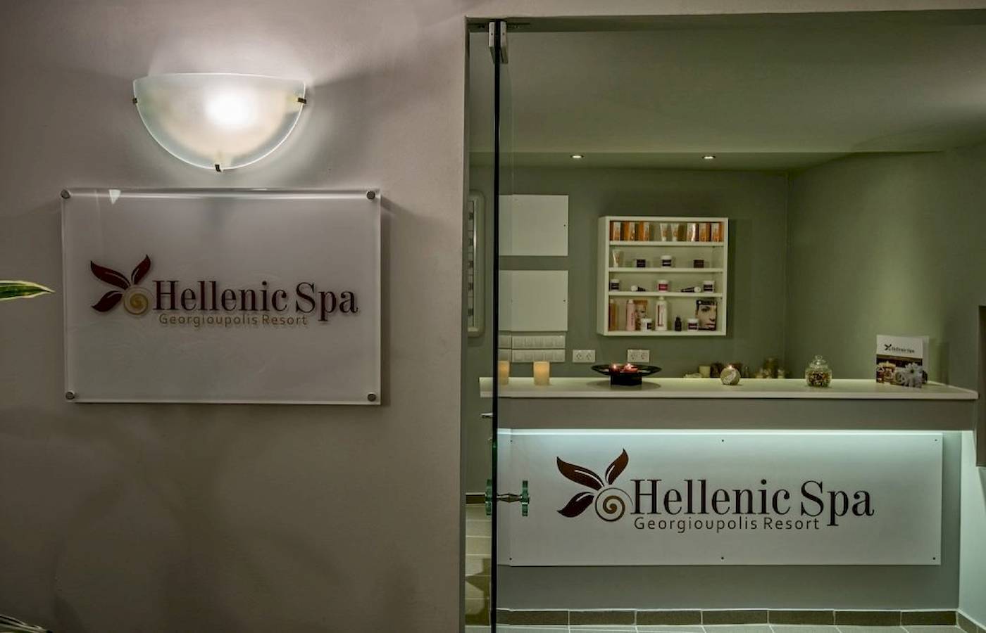 Eingang zum Hellenic Spa im Georgioupolis Resort mit Logo und Beleuchtung.