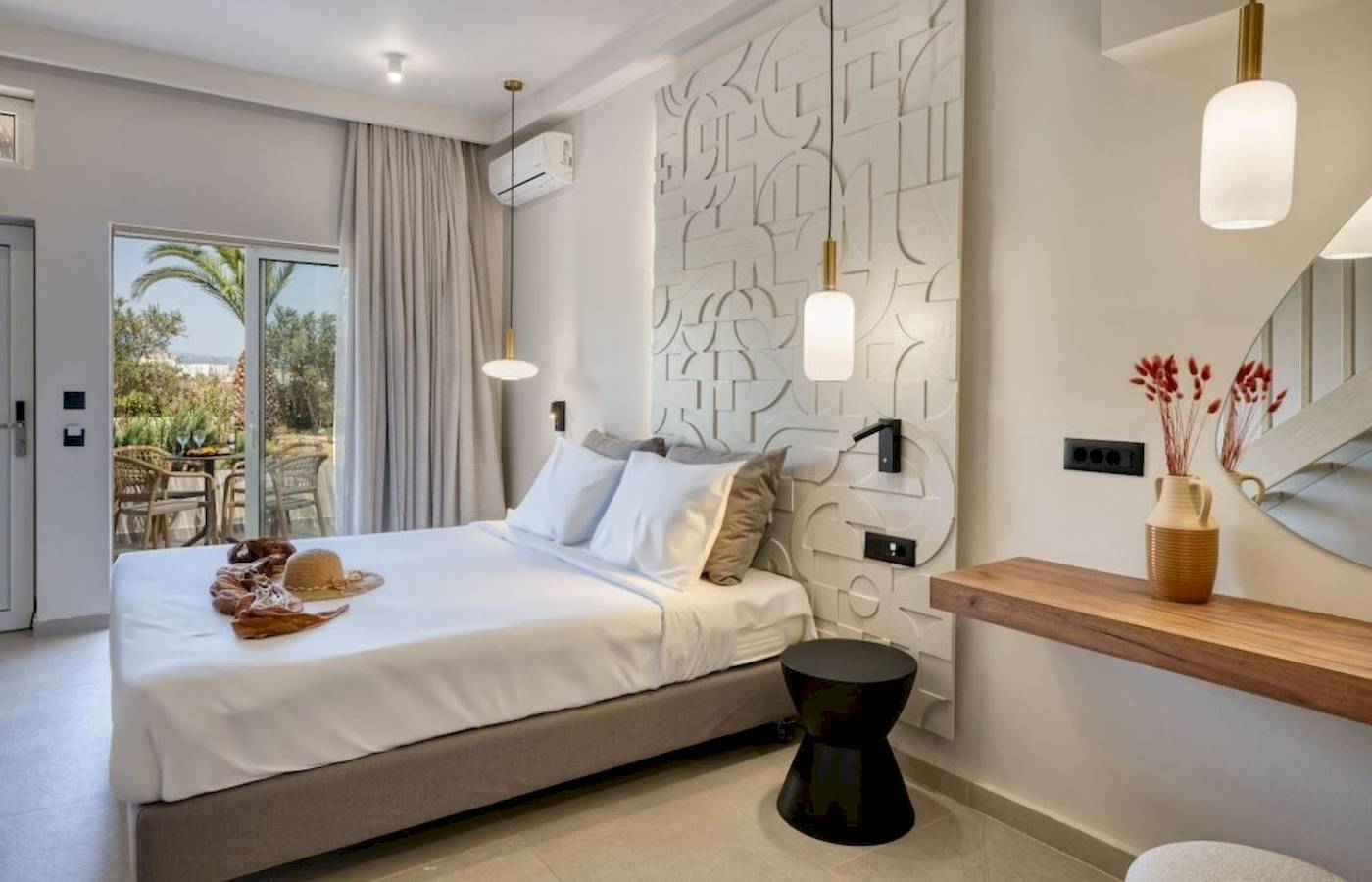 Innenansicht eines Schlafzimmers im Georgioupolis Resort Aquapark & SPA mit Bett, Dekor und Terrassenzugang.