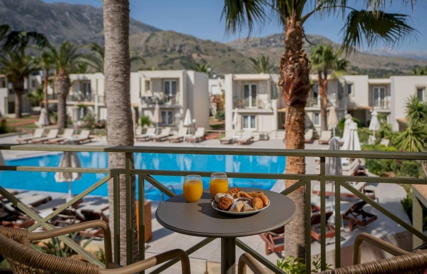 Frühstücksbuffet auf dem Balkon des Georgioupolis Resort Aquapark & SPA mit Blick auf den Pool und die Berge