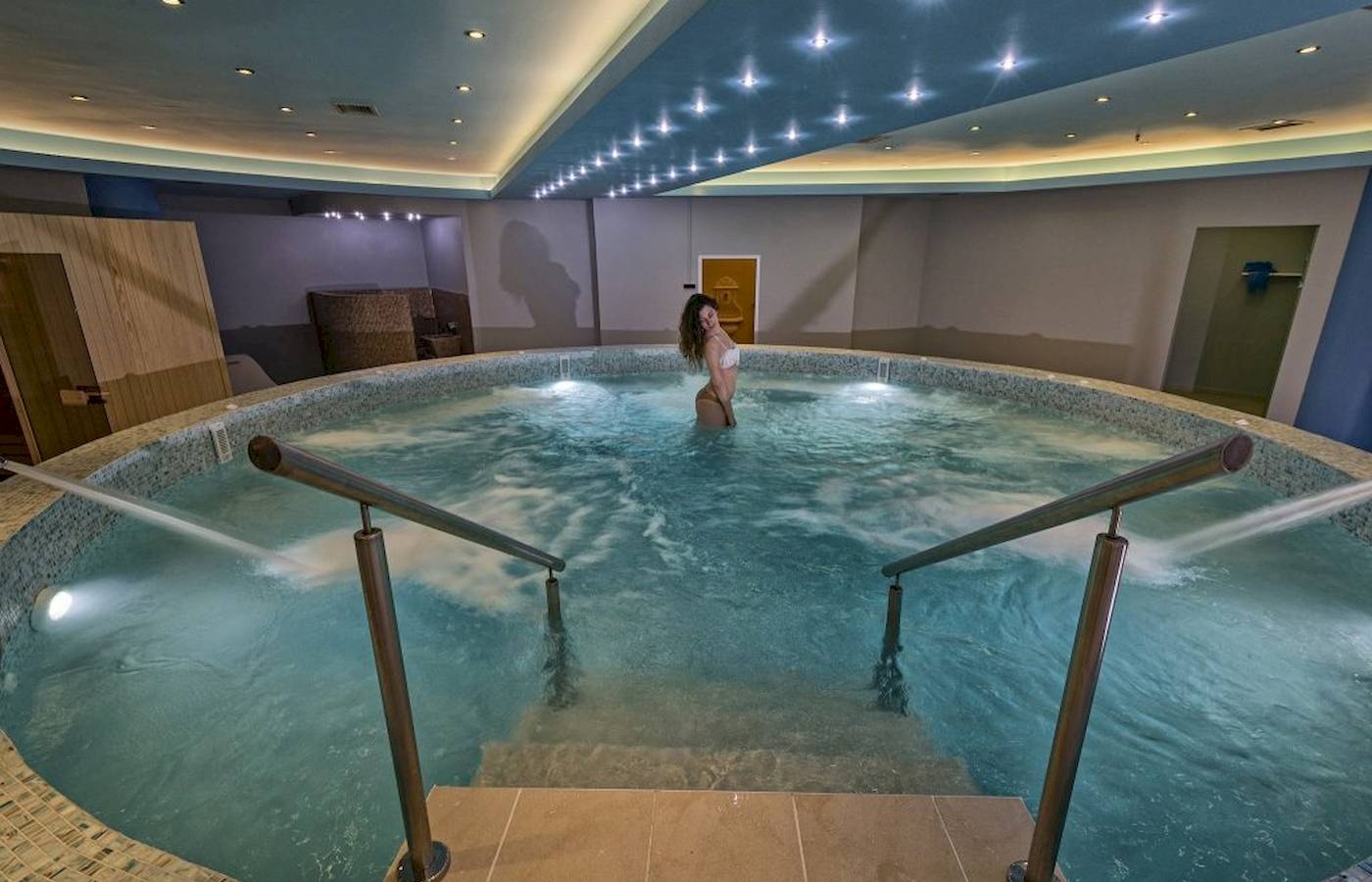 Eine Frau steht in einem beheizten Innenpool des Georgioupolis Resort Aquapark & SPA.