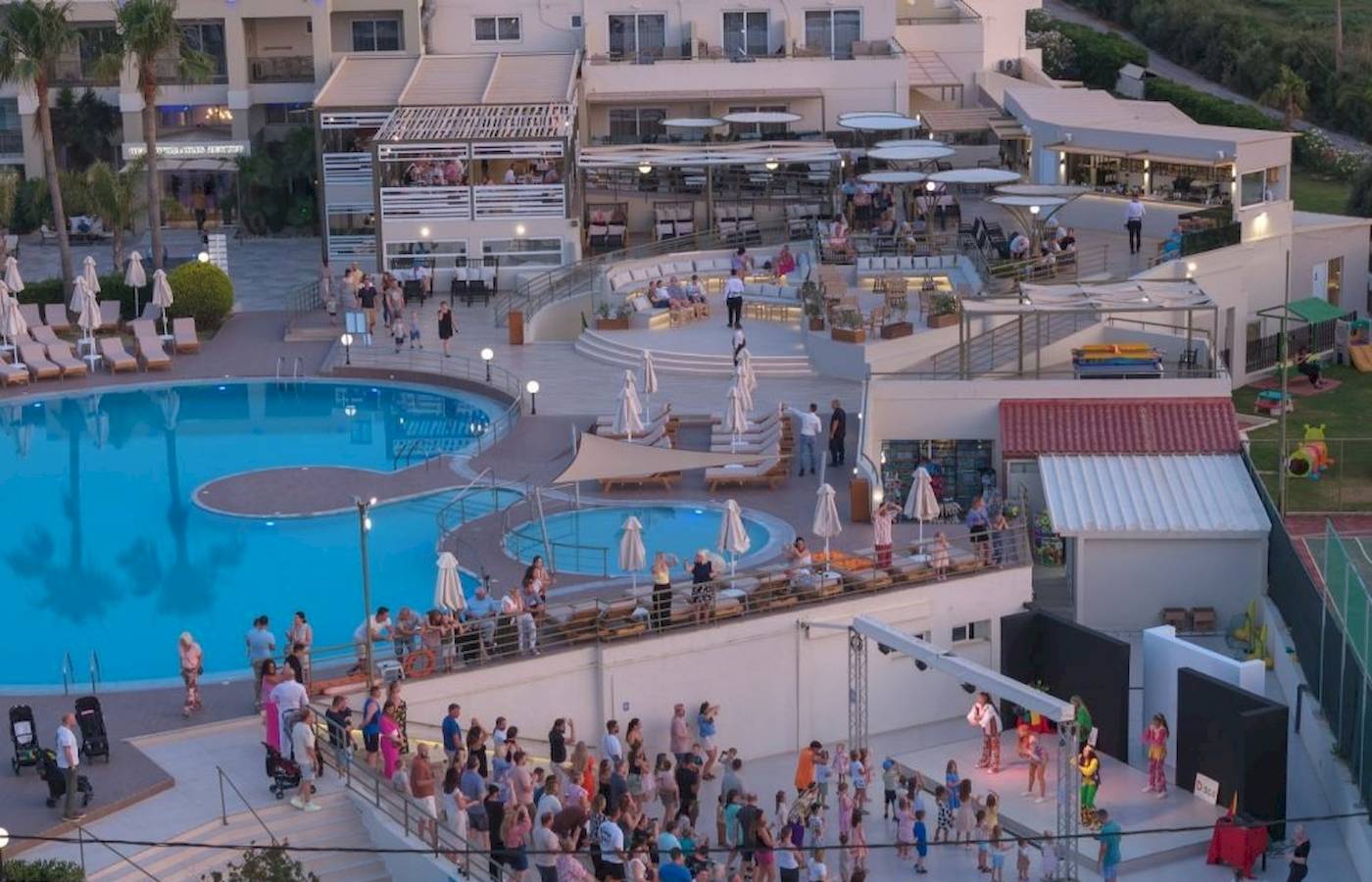 Georgioupolis Resort Aquapark & SPA Abendveranstaltung mit vielen Gästen an Pools und Terrassen.