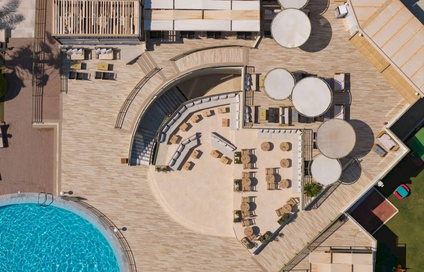 Luftaufnahme des Georgioupolis Resort Aquapark & SPA mit Poolbereich und Terrassenmöbeln.