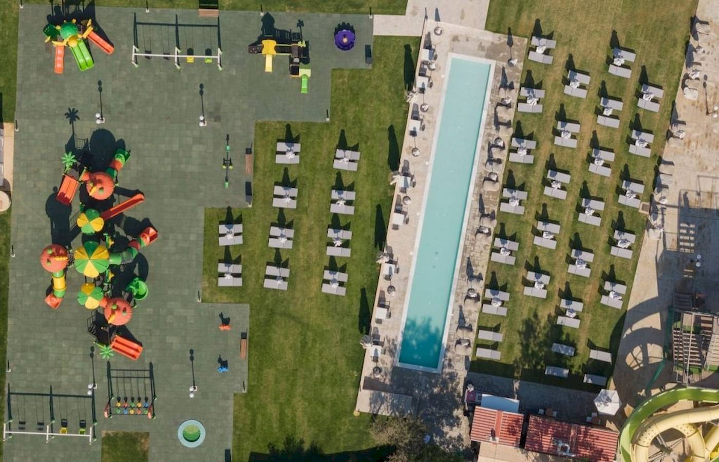 Luftaufnahme des Georgioupolis Resort Aquapark & SPA mit Wasserrutsche, Spielplatz und Sonnenliegen.
