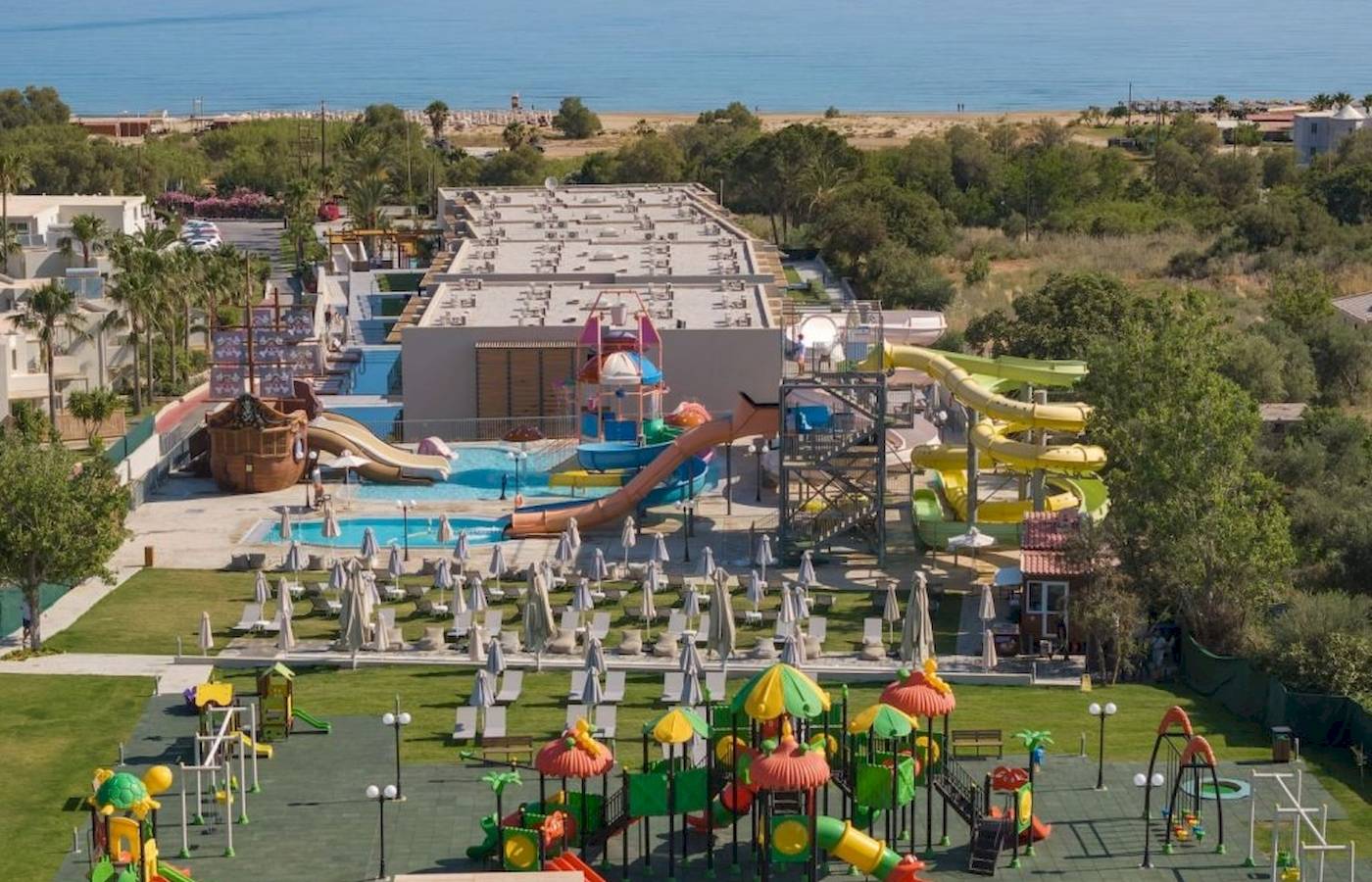 Luftaufnahme des Georgioupolis Resort Aquapark & SPA mit Wasserrutschen, einem Pool und Spielplatz.