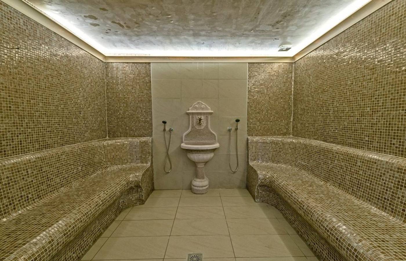 Saunaraum im Georgioupolis Resort Aquapark & SPA mit gefliesten Wänden und Bänken.