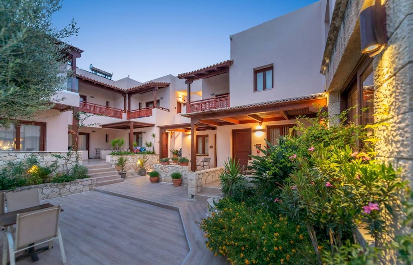 Außenbereich des Cactus Village Hotel & Bungalows mit Gehweg, Pflanzen und Gebäuden.