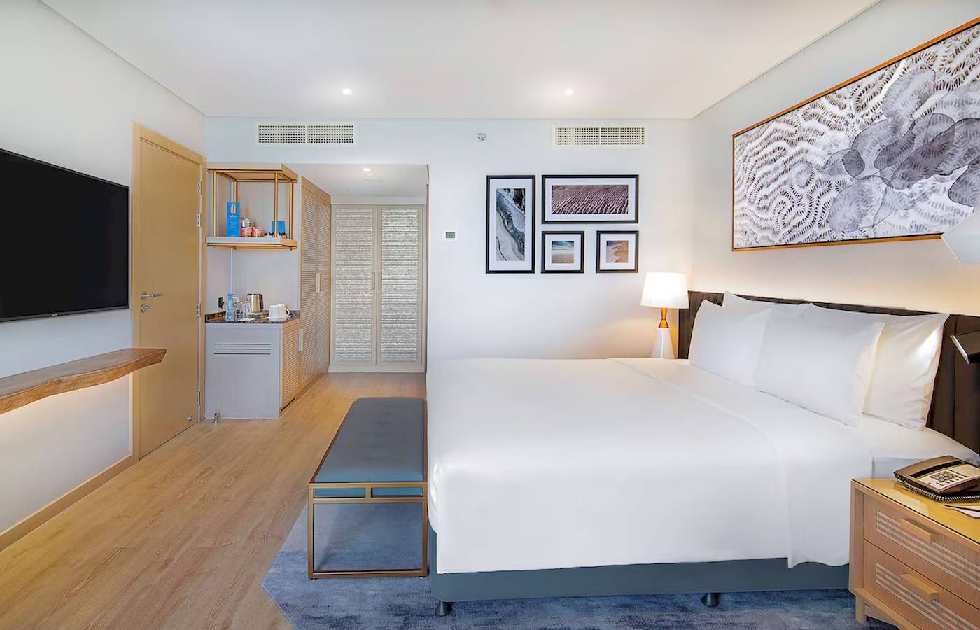 Innenansicht eines Gästezimmers im Radisson Blu Hotel & Resort, Abu Dhabi Corniche, mit Bett, Fernseher, und Dekor.