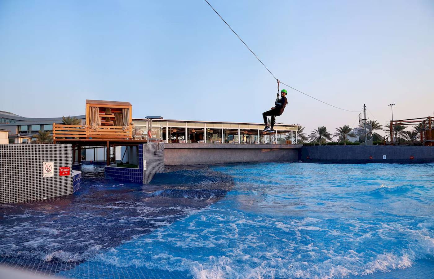 Person zippt über eine Wasserwelle am Radisson Blu Hotel & Resort, Abu Dhabi Corniche
