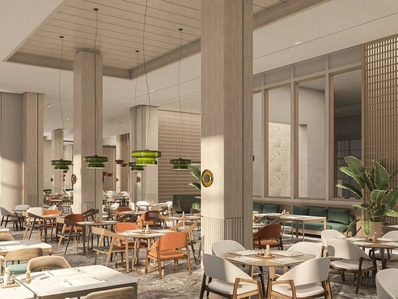 Innenansicht des Jaz Elite Amara Restaurants mit Tischen, Stühlen und Pflanzen.