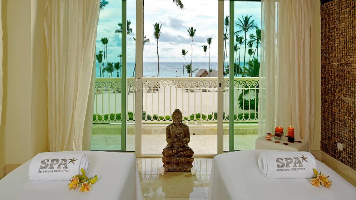 Spa-Behandlungsraum im Hotel JOIA Bávaro by Iberostar mit Blick auf das Meer und Palmen.