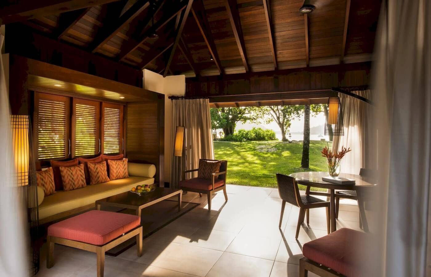 Innenbereich des Constance Ephelia Resorts mit Wohnzimmermöbeln und Blick auf eine Wiese.