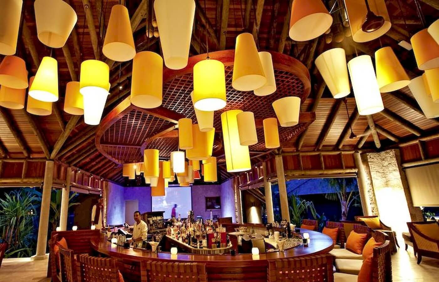 Die Bar im Constance Ephelia Resort mit vielen gelben Lampen an der Decke.