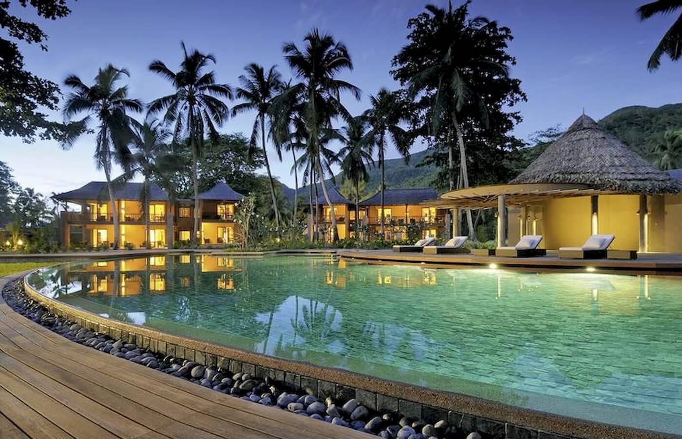 Constance Ephelia Resort Pool bei Nacht mit Beleuchtung und Gebäuden im Hintergrund.