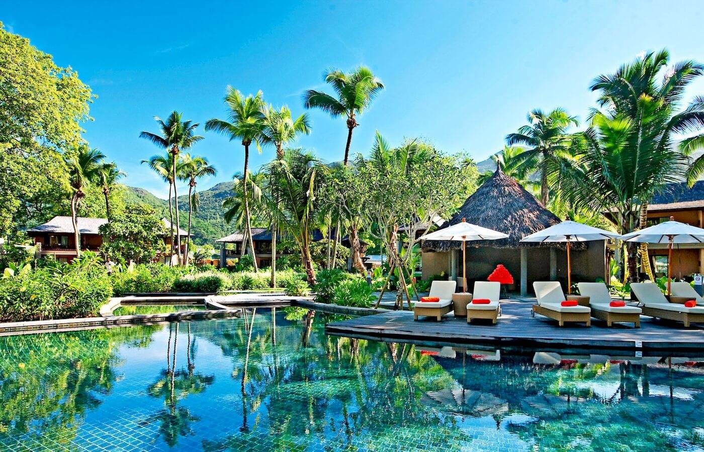 Pool-Lounge-Bereich des Constance Ephelia Resorts mit Palmen und Liegestühlen