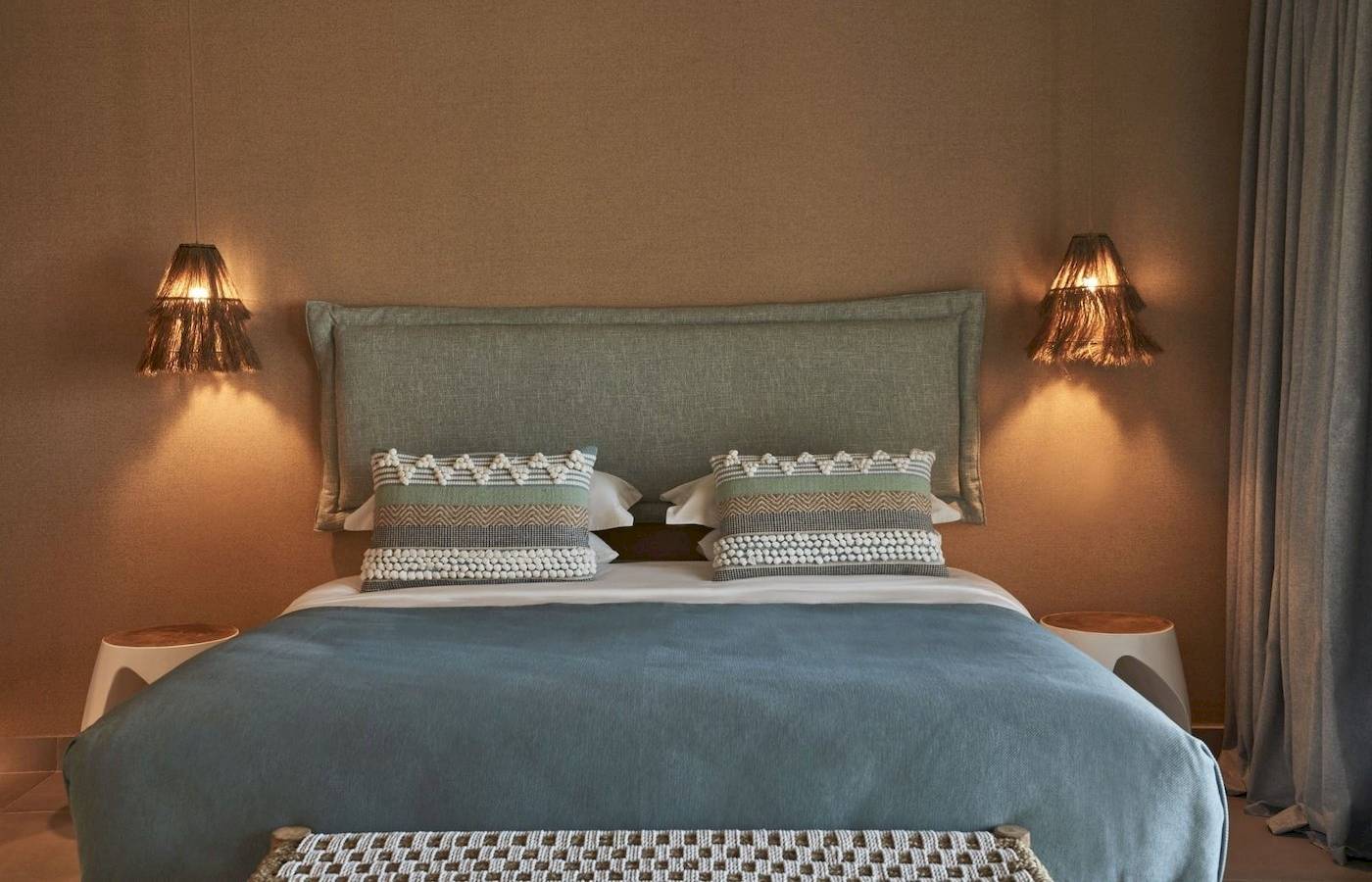 Schlafzimmer im Atlantica Beach Resort Kos mit zwei Nachttischen, dekorativen Lampen und einem bequemen Bett.